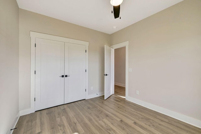 unfurnished bedroom featuring a closet, ceiling fan, and light wood-type flooring