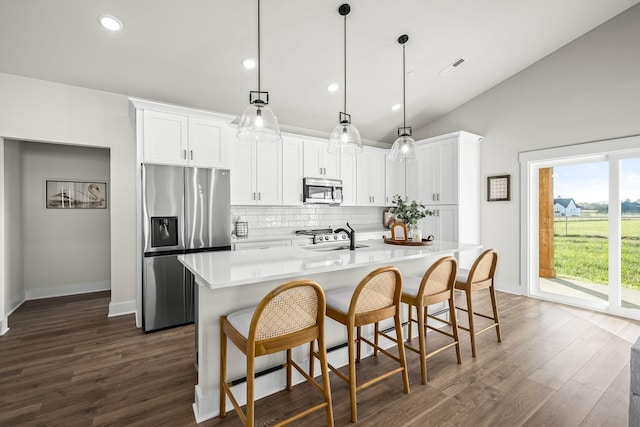 kitchen featuring stainless steel appliances, hanging light fixtures, and white cabinets