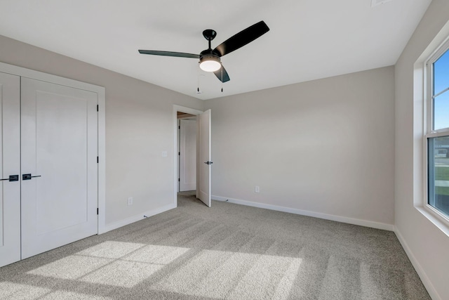 unfurnished bedroom with ceiling fan and light colored carpet