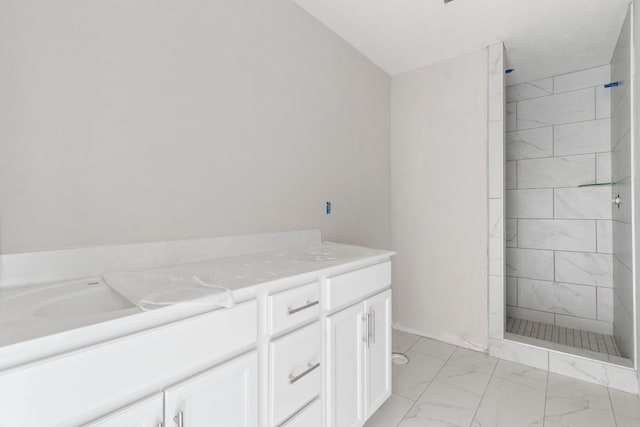 bathroom with vanity and a tile shower