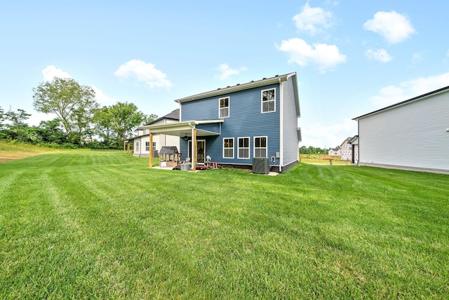 back of house with central AC unit, a yard, and a patio area