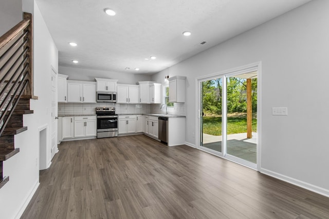 kitchen featuring stainless steel appliances, white cabinetry, tasteful backsplash, and dark hardwood / wood-style floors