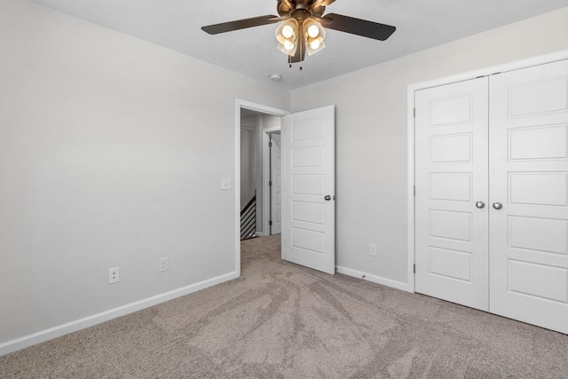 unfurnished bedroom featuring light colored carpet, a closet, and ceiling fan