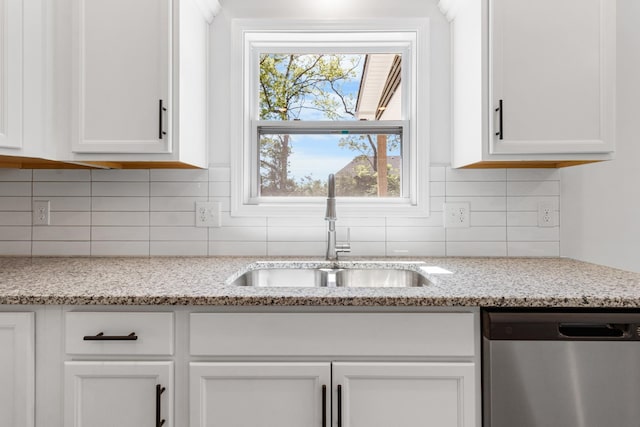 kitchen with white cabinetry, dishwasher, sink, and light stone countertops