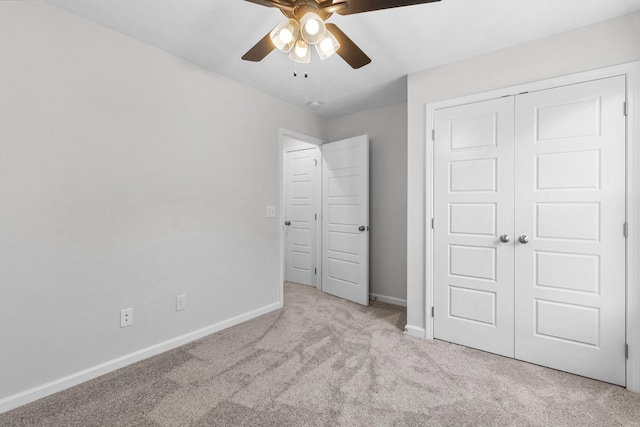 unfurnished bedroom featuring ceiling fan, light colored carpet, and a closet