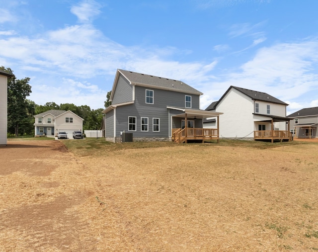 back of property featuring a wooden deck, a yard, and cooling unit