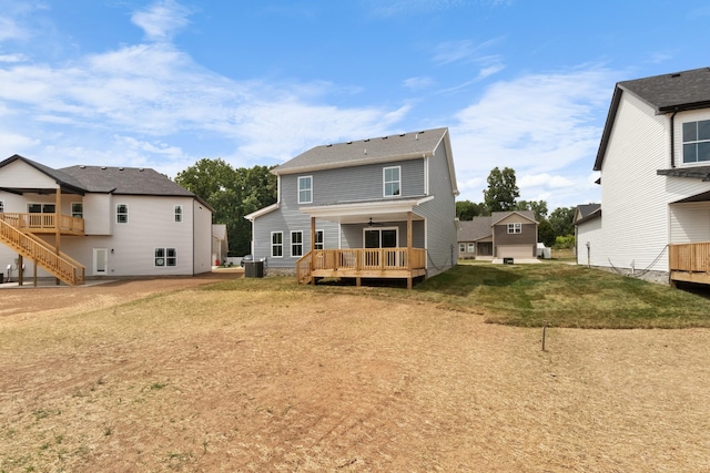 rear view of property featuring central AC, a deck, and a lawn