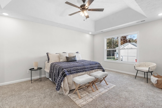 bedroom featuring ceiling fan, carpet flooring, and a raised ceiling