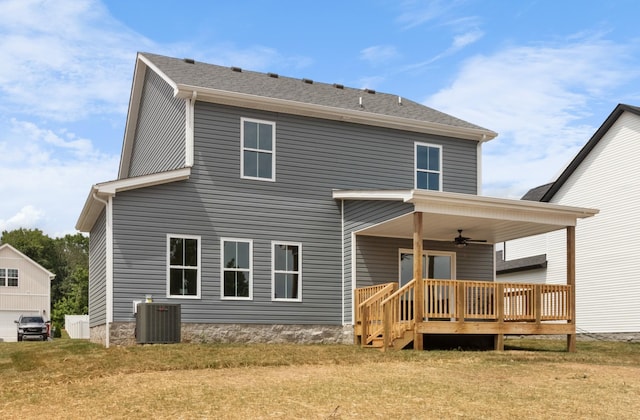 back of property with cooling unit, ceiling fan, a deck, and a lawn