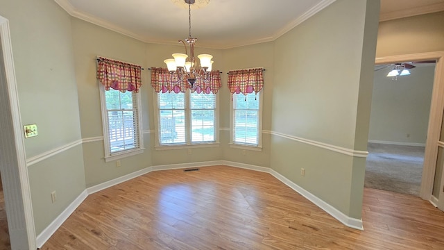 unfurnished dining area featuring ornamental molding, ceiling fan with notable chandelier, and light hardwood / wood-style flooring