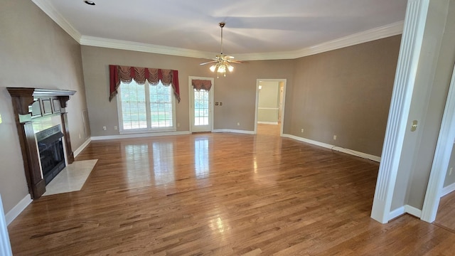 unfurnished living room with wood-type flooring, ceiling fan, and crown molding