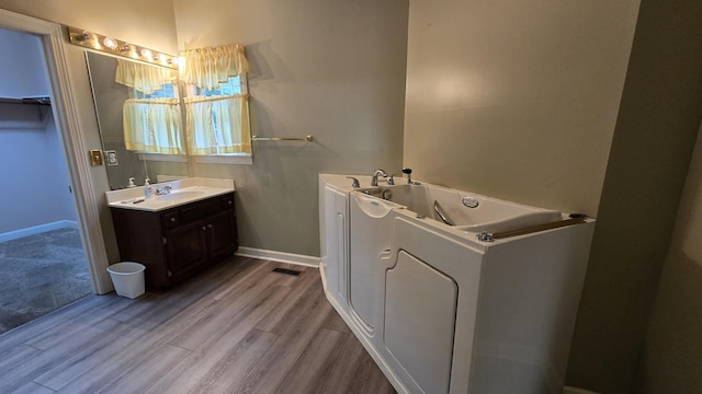 bathroom with vanity, washer / dryer, and wood-type flooring