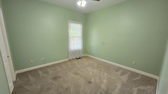 carpeted spare room featuring ceiling fan