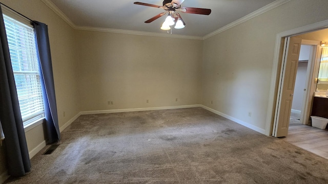 unfurnished room with ornamental molding, plenty of natural light, light carpet, and ceiling fan