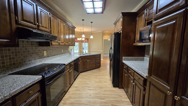 kitchen featuring black appliances, hanging light fixtures, ornamental molding, light hardwood / wood-style floors, and backsplash