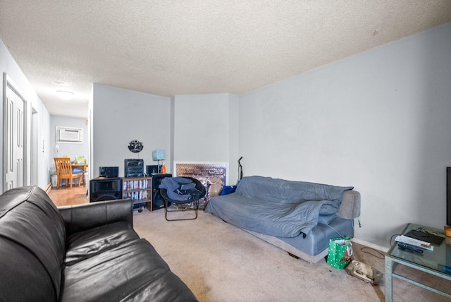 living room with carpet floors, a wall unit AC, and a textured ceiling