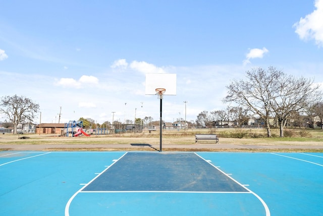 view of basketball court featuring a playground