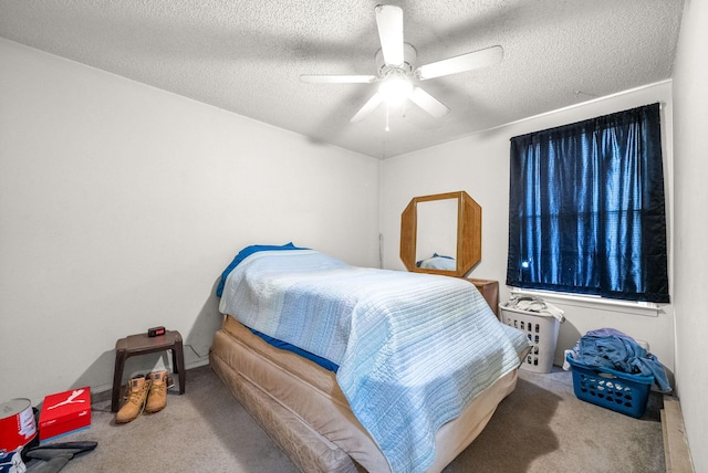 bedroom featuring ceiling fan, carpet floors, and a textured ceiling