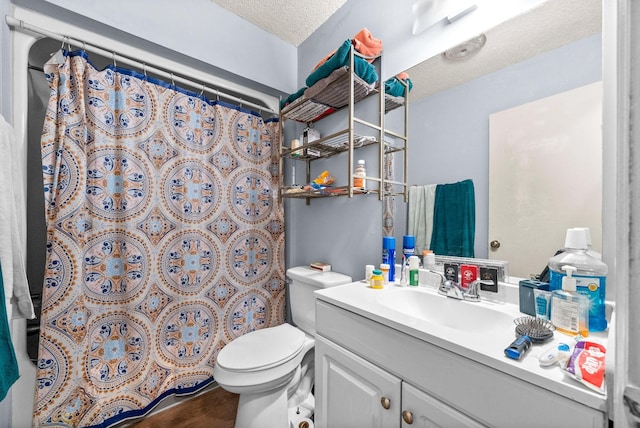 bathroom featuring vanity, walk in shower, a textured ceiling, and toilet