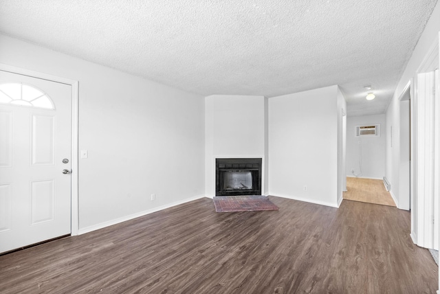 unfurnished living room featuring dark wood-type flooring and a textured ceiling