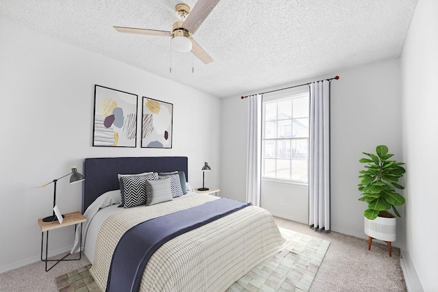 carpeted bedroom with ceiling fan and a textured ceiling