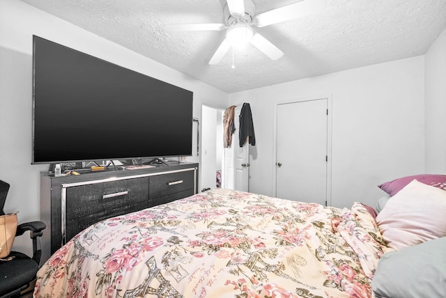 bedroom with ceiling fan and a textured ceiling