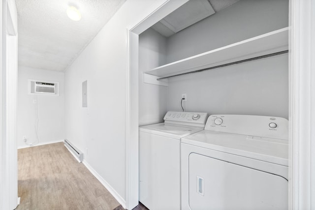 clothes washing area featuring a wall mounted AC, independent washer and dryer, baseboard heating, a textured ceiling, and light hardwood / wood-style flooring