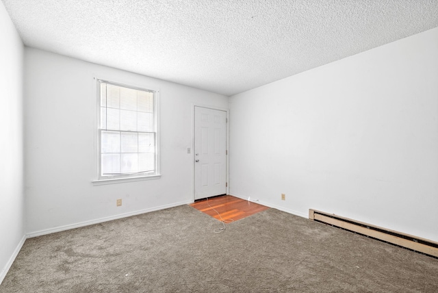 carpeted empty room with a baseboard radiator and a textured ceiling