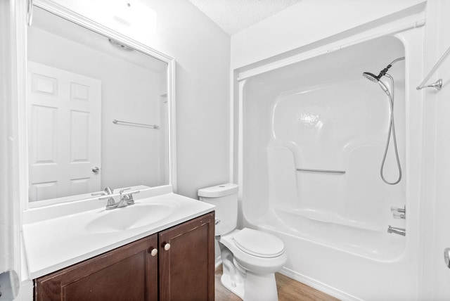 full bathroom with washtub / shower combination, toilet, wood-type flooring, a textured ceiling, and vanity