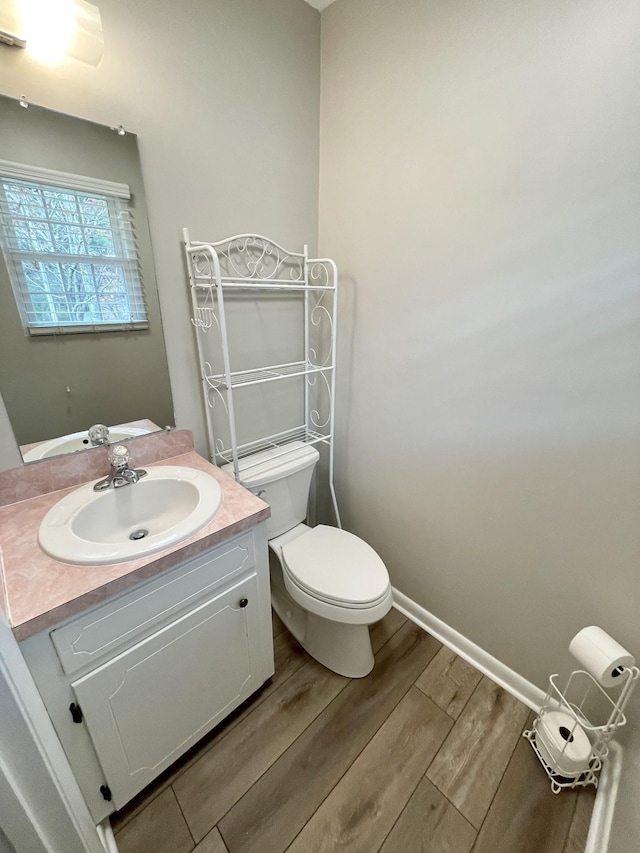 bathroom featuring wood-type flooring, toilet, and vanity