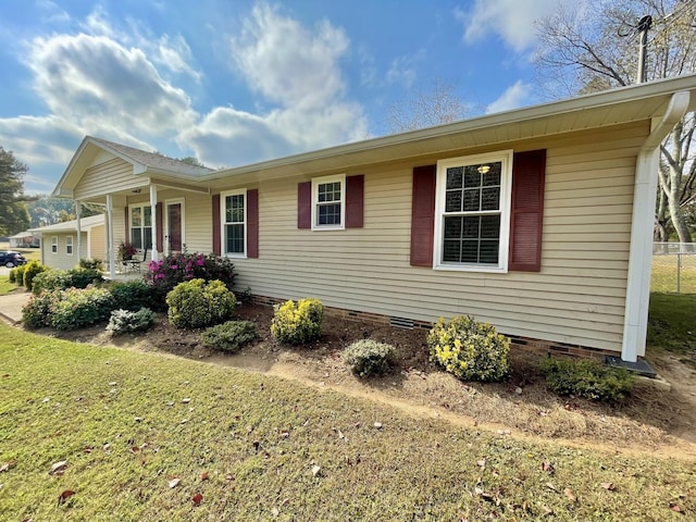 view of side of home with a porch and a lawn