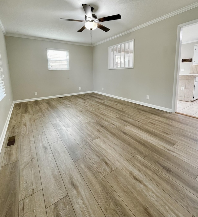 unfurnished room featuring crown molding, light hardwood / wood-style floors, ceiling fan, and a textured ceiling