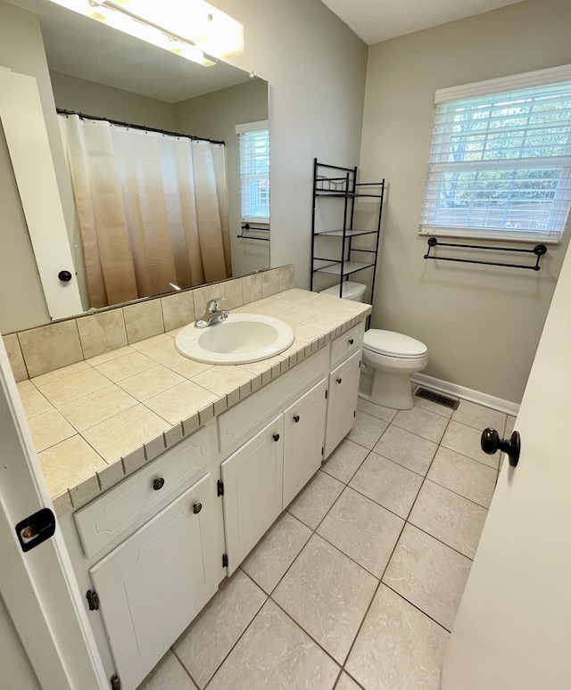 bathroom with tile patterned flooring, vanity, and toilet