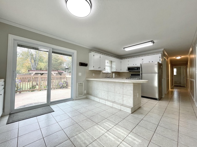 kitchen featuring stainless steel appliances, light tile patterned floors, white cabinets, and kitchen peninsula