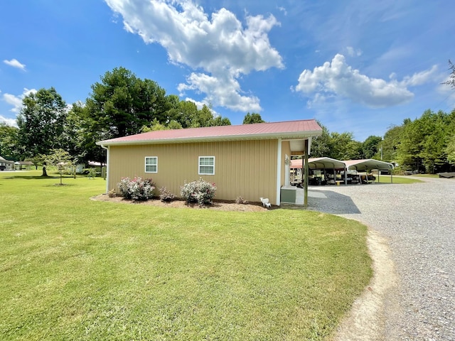 view of home's exterior featuring a carport and a lawn