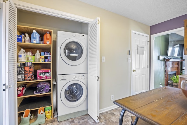 laundry room featuring stacked washer / dryer and a textured ceiling