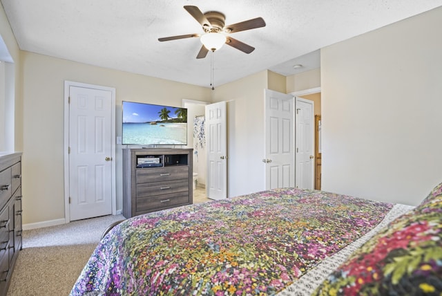 bedroom featuring ceiling fan, light colored carpet, and a textured ceiling