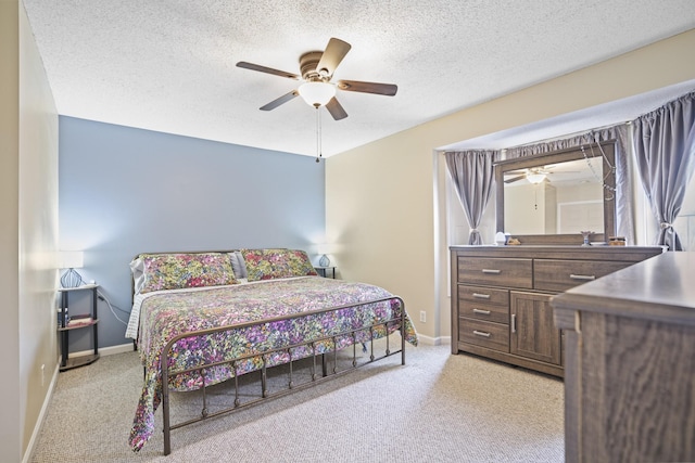 bedroom featuring ceiling fan, light colored carpet, and a textured ceiling