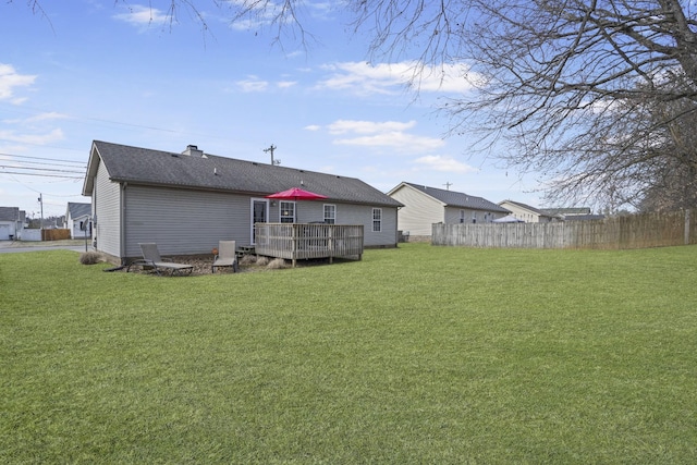 rear view of house with a wooden deck and a yard