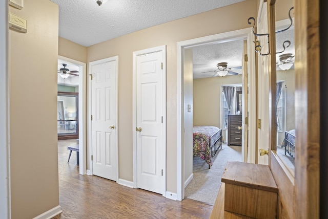 hallway with wood-type flooring and a textured ceiling