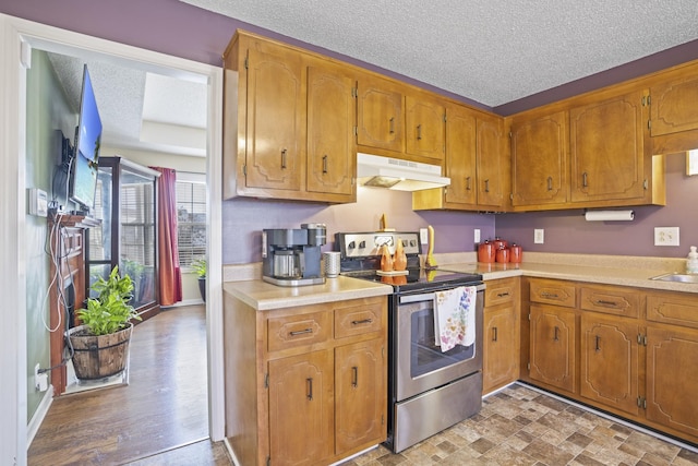 kitchen featuring sink, a textured ceiling, and electric range