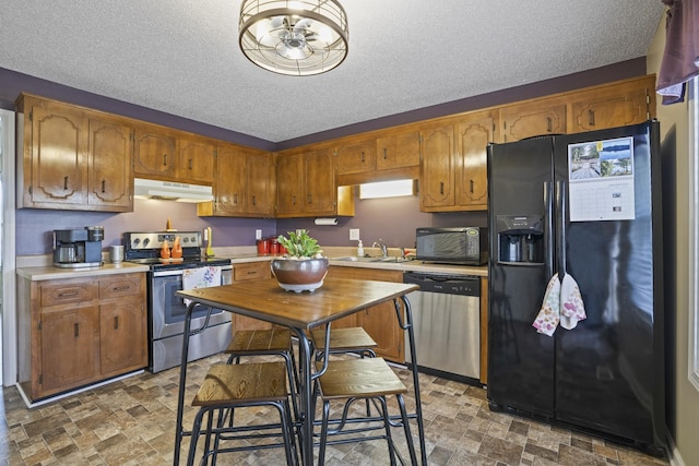 kitchen featuring sink, black appliances, and a textured ceiling