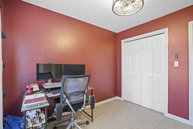 home office featuring carpet floors and a textured ceiling