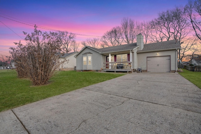 ranch-style home with a yard, a garage, and covered porch