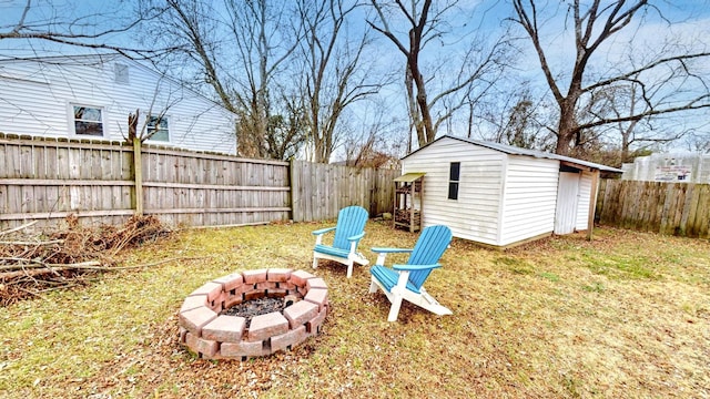 view of yard featuring a storage unit and an outdoor fire pit