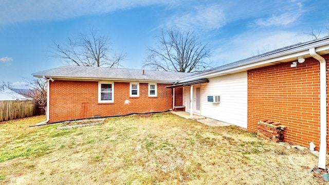 back of property with a yard and an AC wall unit