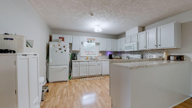 kitchen with sink, white appliances, white cabinetry, tasteful backsplash, and light wood-type flooring