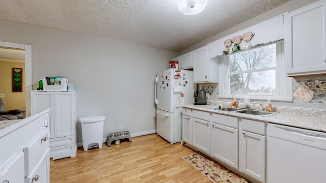 kitchen with sink, white cabinets, white appliances, light hardwood / wood-style floors, and a textured ceiling