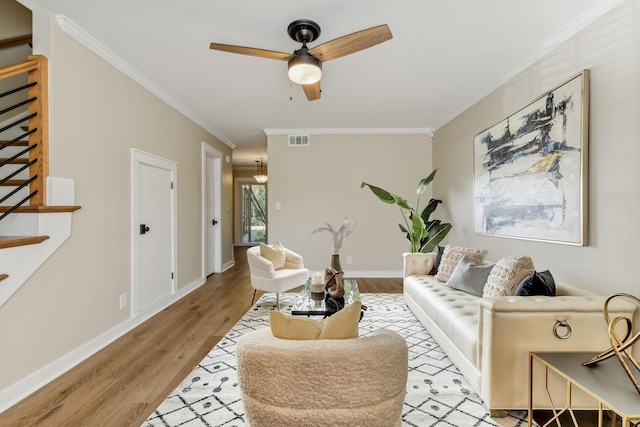 living room with crown molding, ceiling fan, and light hardwood / wood-style floors