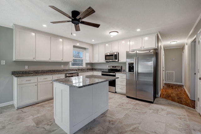 604 W 4th Ave, Hohenwald, TN 38462 - kitchen featuring white cabinetry, dark stone counters, and appliances with stainless steel finishes
